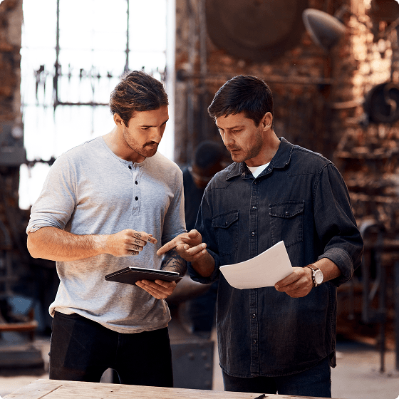Two professionals collaborating on documents in a modern office space